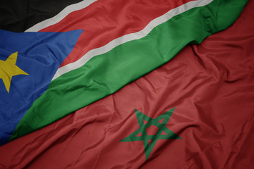 waving colorful flag of morocco and national flag of south sudan.