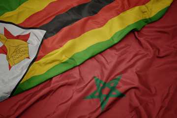waving colorful flag of morocco and national flag of zimbabwe.
