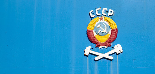 sickle and hammer, coat of arms and symbol of the Soviet Union on the metal cell of the locomotive