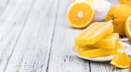 Homemade orange popsicles on a vintage background (selective focus)