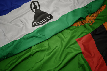 waving colorful flag of zambia and national flag of lesotho.