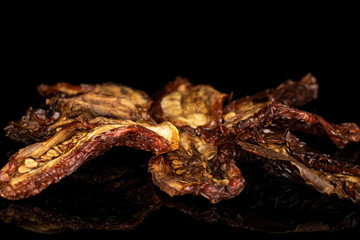 Group of eight whole dried red tomato piece isolated on black glass