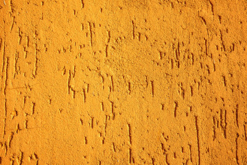 Rough, bright orange painted plaster or stucco wall. Abstract grunge background with copy space.