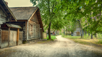 Fototapeta na wymiar Riga, Latvia, panorama old wooden village with residential buildings, a chapel in the forest of the Ethnographic Museum in the open air 