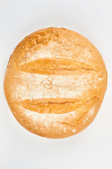 Round wheat bread on white background. Loaf of freshly baked bread, top view.