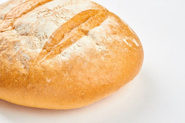 Fresh homemade bread on white background. Round loaf of bread close up. Crusty bread recipe.