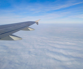 Fototapeta na wymiar Milky clouds under the airplane wing