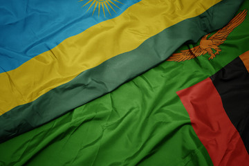waving colorful flag of zambia and national flag of rwanda.
