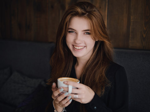 Close Up Headshot Beautiful Caucasian Red Haired Woman Holding Mug Drinking Cappuccino Coffee With Latte Art Adorable Smile And Feeling Good In Trendy City Cafe