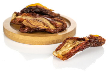 Lot of whole dried red tomato piece front focus on round bamboo coaster isolated on white background