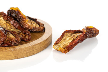 Lot of whole dried red tomato piece on round bamboo coaster isolated on white background