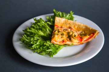 Slice of pizza on a plate with a salad leaf