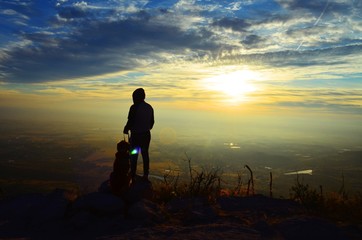 Hombre con su perro arriba de una montaña 