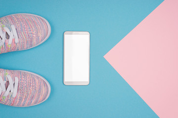 Mock up for Mobile app. Modern fitness and gym workout concept. Healthy lifestyle Flat lay background with blank copy space smartphone screen and sport training shoes close up.