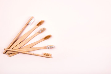 Top view of bamboo toothbrushes on pink background. Plastic free concept. Place for text.