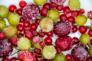 Frozen berries from the freezer. Background with frozen cherries, currants and gooseberries. Healthy berry mix.