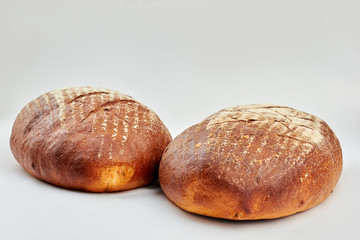Two loaves of freshly baked bread. Artisan bread isolated on white background. How to bake healthy bread.