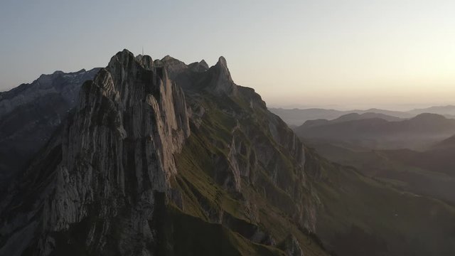 Sunset view of the mountains and dramatic peaks. Flying from above. 