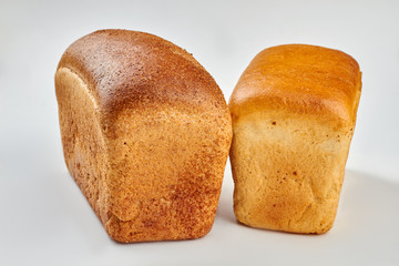 Brown and white bread. Two loaves of fresh bread. Isolated on white background.