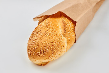 French bread in kraft bag. French baguette with sesame seeds in kraft paper packaging.