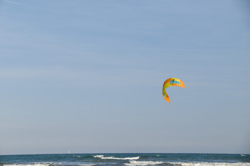 yellow and orange kitesurf sail in the sky