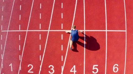 Top view of a track runner athlete at starting line on stadium lane, 4k