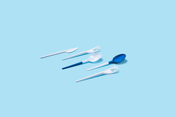 Dangerous and needed two plastic spoons. Environmental problem of plastic rubbish pollution. Flat lay, top view, copy space.