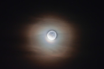 The moon among the stars and clouds