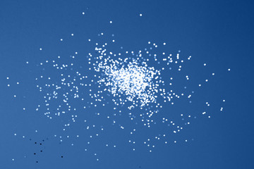 Glittering stars on arctic blue background. Festive holiday backdrop.