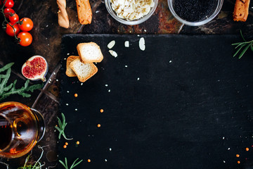 Cooking dark stone board with herbs, spices and vegetables. Top view with copy space