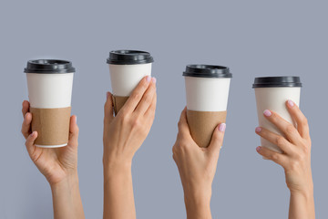 Mockup of several female hands holding up a Coffee paper cup