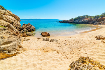 Golden sand and rocks in a small cove in Alghero