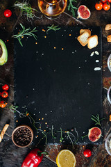 Cooking dark stone board with herbs, spices and vegetables. Top view with copy space