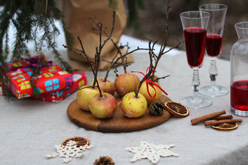 Fototapeta na wymiar Festive table in the forest. On the table Apple dessert and red drink in glasses.