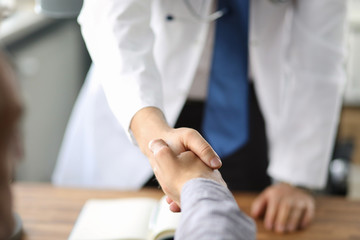 Closeup image of healthcare professional or doctor or dentist shaking hands with patient. - 309824475