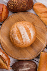 Bread on wooden trey, top view. Assorted homemade bread on wooden background.
