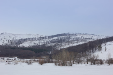 Fototapeta na wymiar Winter snowy landscape with mountains and trees