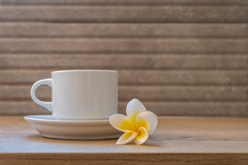 Fototapeta na wymiar Morning cup of coffee and exotic flower on wooden table.