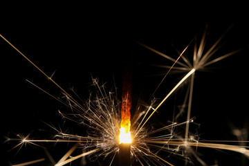 A burning sparkler with black background