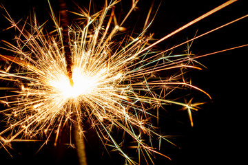 Sparkling sparkler on a black background. New Year theme..