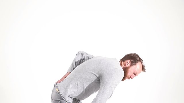 Man with severe back pain hunches over in agony