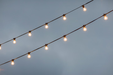 lamp light bulbs on sky background. Christmas street mood