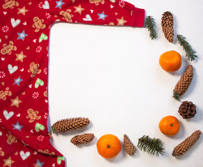 Christmas holidays sweater on white background flatlay. Orange tangerines and spruce cones frame, top view. New year 2020 events celebration style clothes, cute red kids party costume, sleep,play suit