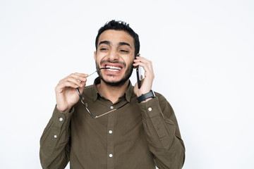 Mixed-race businessman with smartphone by ear and eyeglasses talking to client