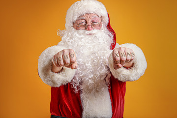 Funny drunk Santa Claus with tattooed hands on color background