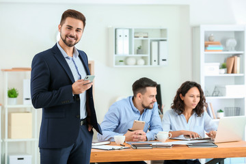 Young businessman with his partners in office