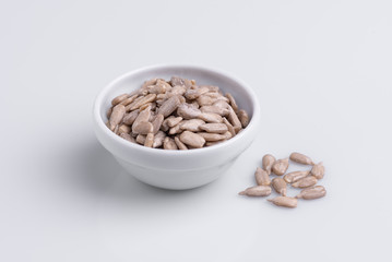 Peeled Sunflower seeds isolated on white background. Soft light, studio shot, copy space.