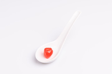 Maraschino cherry in a white bowl, isolated on white background, soft light, studio shot