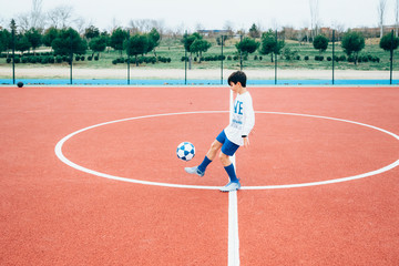 Soccer player boy hitting the ball