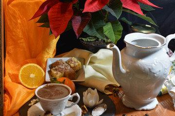coffee with pastries and orange surrounded by plants